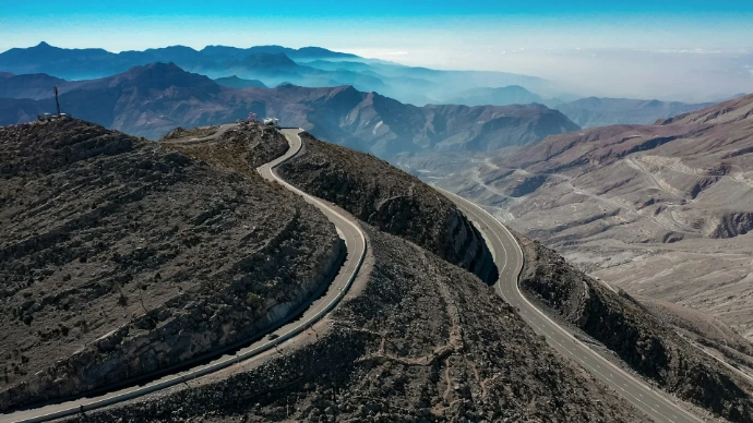 an aerial view of a winding road in the mountains